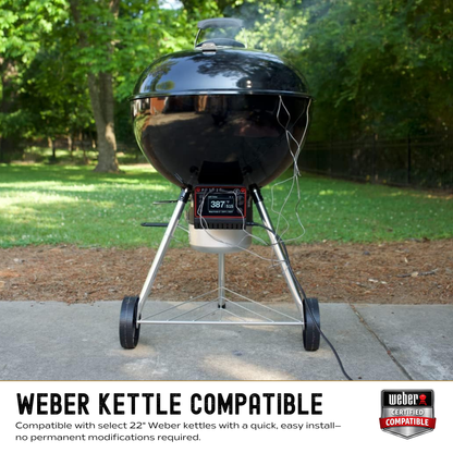 Black kettle grill on wheels with a digital display in an outdoor setting, featuring Weber branding.